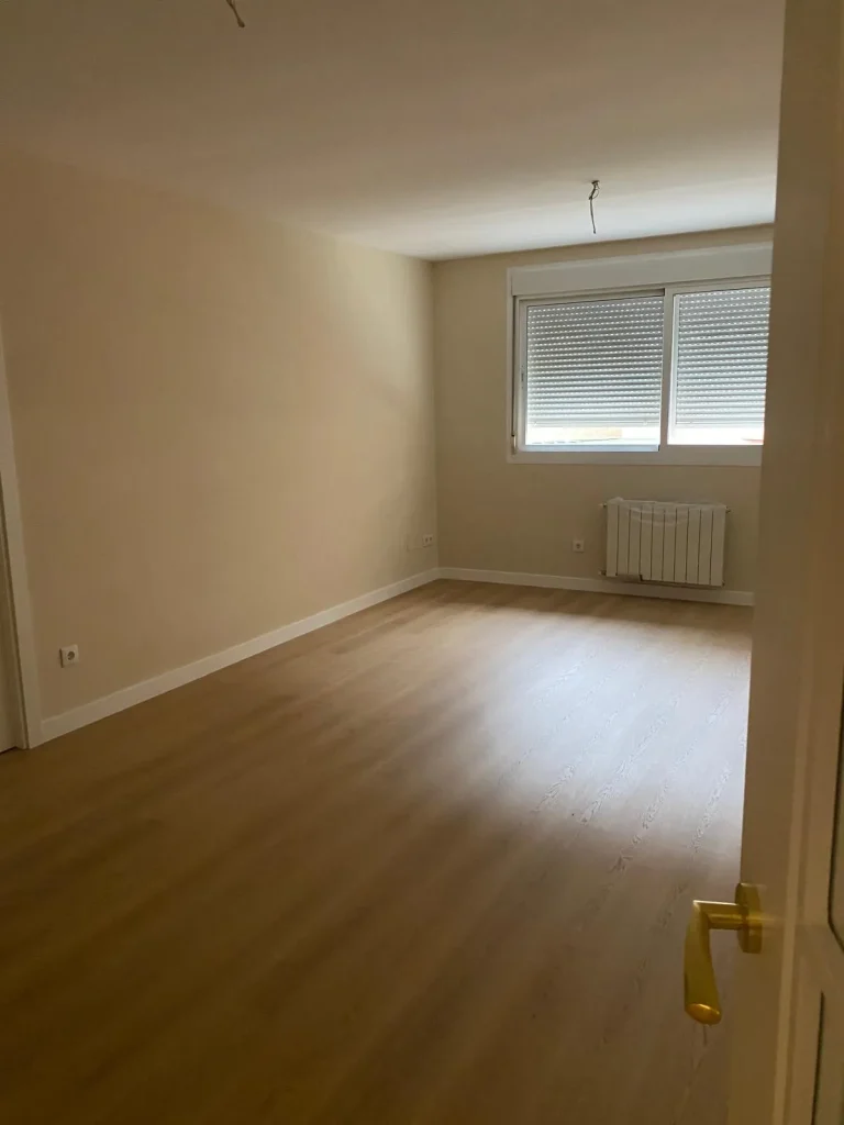 Estancia reformada con suelo laminado, paredes lisas y puerta de paso, en el paseo de Arroyomolinos de Móstoles