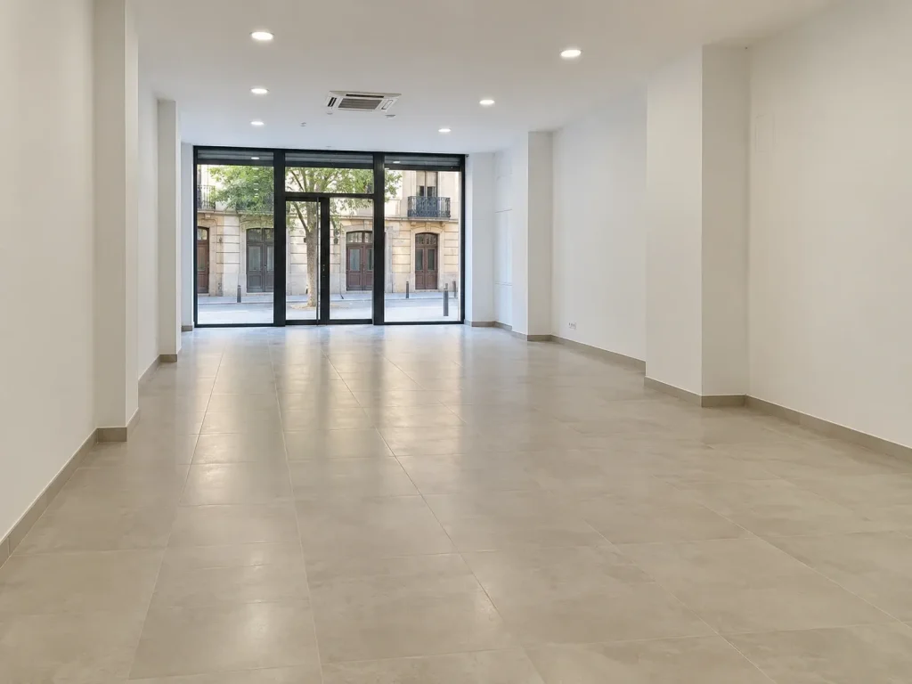 Local comercial reformado con escaparate de cristal, suelo porcelánico y techo con iluminación empotrada y climatización