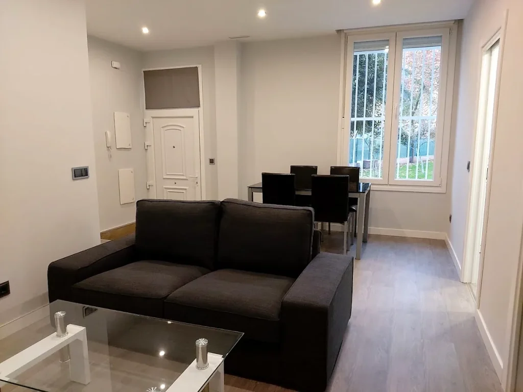 Salón comedor reformado con suelo laminado y puerta de entrada blanca